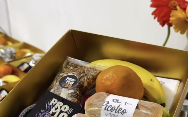 Box lunch dorado con sándwiches, fruta y granola