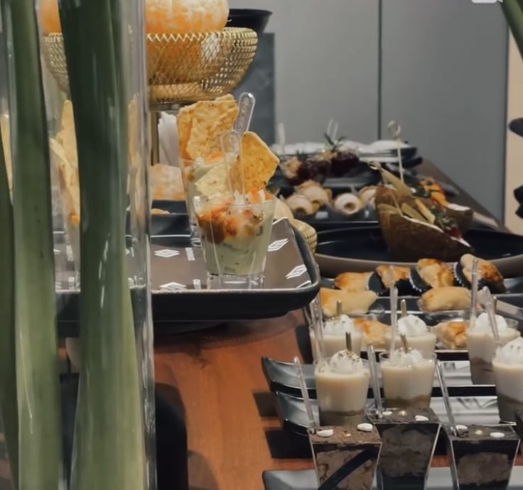 Mesa de pasapalos y postres en vasitos servida en un evento de El Picoteo
